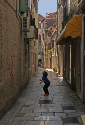Boy Playing Narrow Street