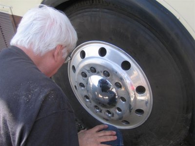 SATISFIED THAT THE BRAKES WERE OK, HE MOUNTS THE WHEEL BACK ON.