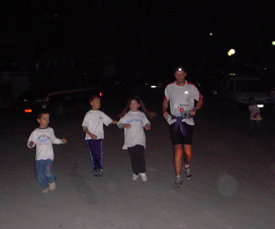 kids run with the runners down the hill and into the aid station