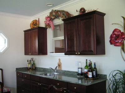 The eight-foot cherry bar has a granite counter with stainless sink, plus cabinets and a pass-through to the kitchen above.jpg