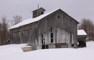 worn wood barn in snow