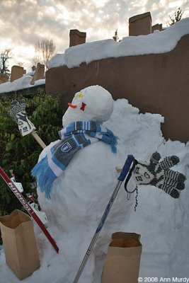 Snowman with skis and farolitos