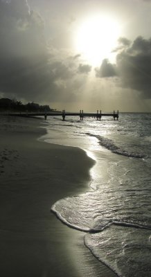 View of sun rays, beach, and pier