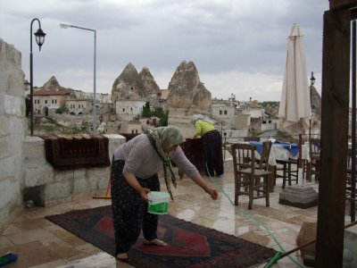 Goreme: Sprinkling soap on the carpet.  Brushes and squeegies are the cleaning tools.