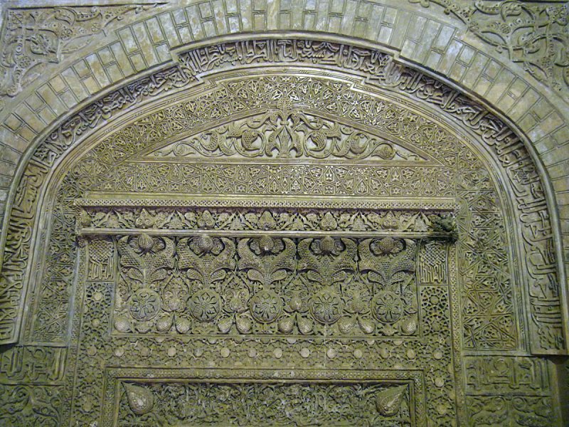 an exquisite stucco mihrab awash with dense Quranic inscriptions and foral designs
