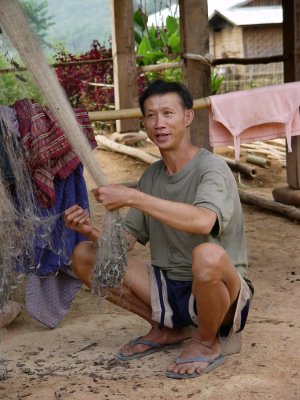 Khmu man fixing his fishing net