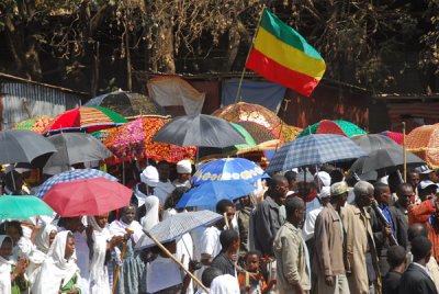 The priests are under the colorful umbrellas