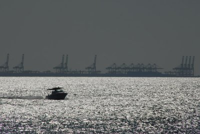 Cranes of the Port of Jebel Ali with a small pleasure boat