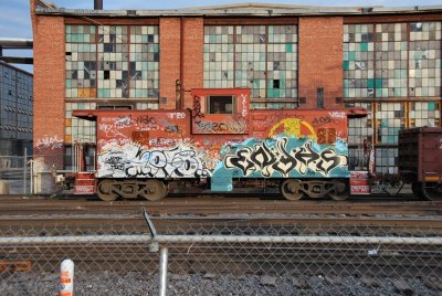 sad-looking caboose in front of sad-looking shops