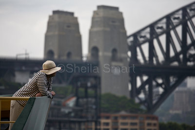 Woman on ferry with Harbour Bridge backdrop