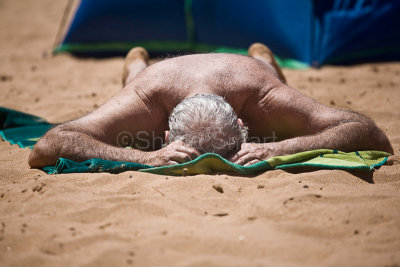 Man on beach sunbathing