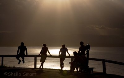 Group in silhouette at Byron Bay lighthouse at sunset