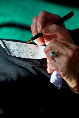 Elderly person filling in sudoku