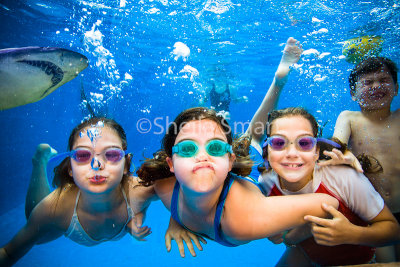 Kids swimming underwater with shark 