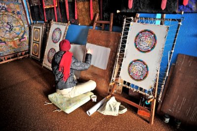 Student artist painting a tankha