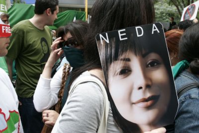 A protester at the UN carrying a poster of Neda Agha-Soltan