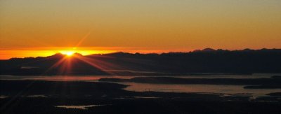 sun burst on Olympics and Puget Sound