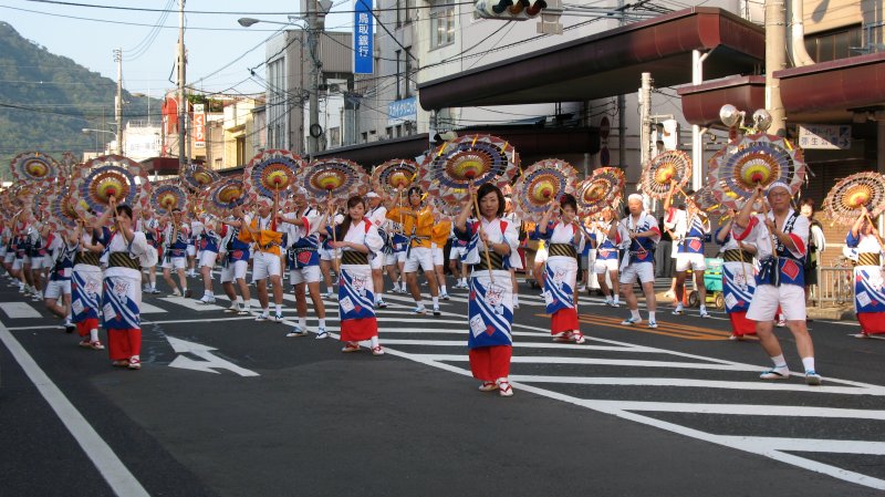 Group of Shan Shan dancers coming down the road