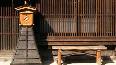 Wooden lantern and bench outside a house