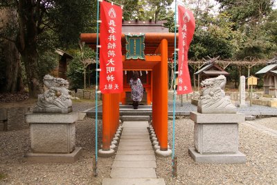 Woman praying at a smaller shrine, Kono-jinja