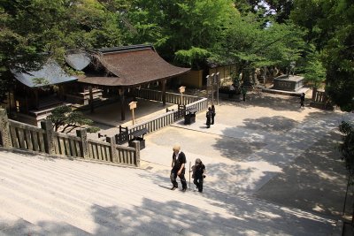 Younger couple climbing the steps past a smaller shrine