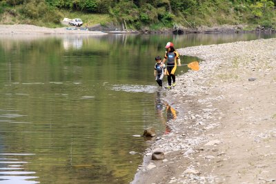Children net-fishing along the riverbank
