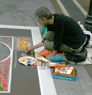A Street Artist copying the work of Mucha