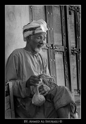 An old man sitting in Rustaq Old Suq