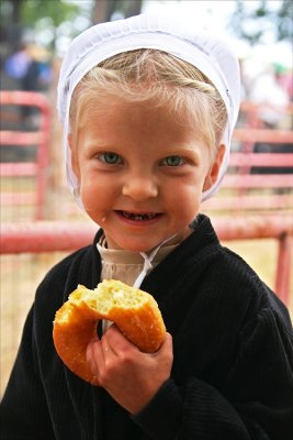 Little Amish girl with a donut.
