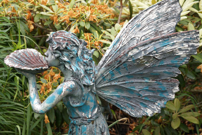 Winged statue blowing on shell.