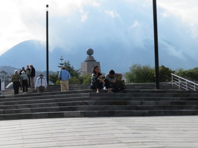 The Mitad del Mundo monument tower with the Andes in the background