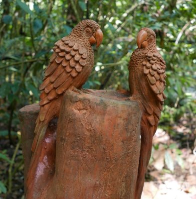 A wood carving of parrots along the trail