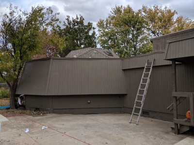 Shane is touching up places around the bathroom exterior.