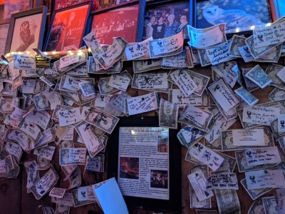 The Owl owners collect the dollar bills customers tack on the walls of their booths and give the money to charities.