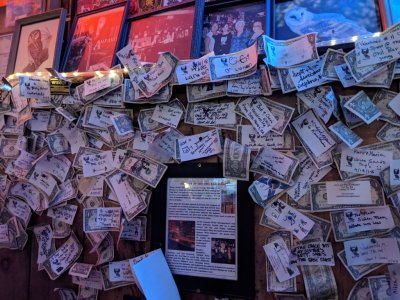 The Owl owners collect the dollar bills customers tack on the walls of their booths and give the money to charities.