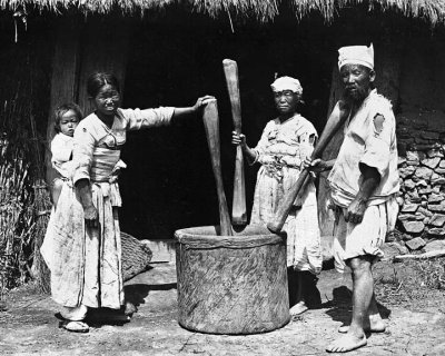 Family with pestles at giant mortar