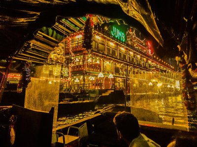 Approaching Jumbo Floating Restaurant by sampan on a drizzly night.  Aberdeen Typhoon Shelter, Hong Kong