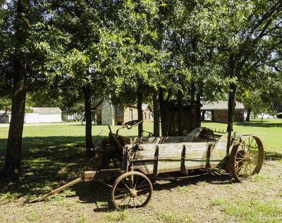 Antique farm machinery with cabins in background