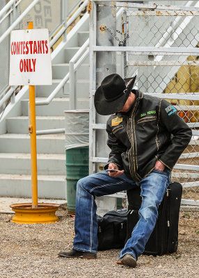 Rodeo contestant waits for a ride after a full day of competition
