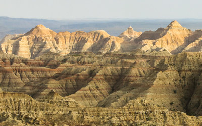 View of hillsides through sunlight and rain in Badlands National Park