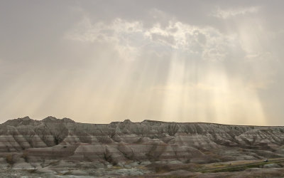 Sunlight streams through the clouds in Badlands National Park