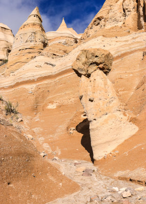 A balanced rock with tent rock formations along the Slot Canyon Trail in Kasha-Katuwe Tent Rocks National Monument