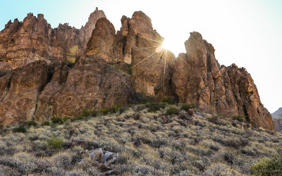 The sun over a Superstition Mountain peak from the Siphon Draw Trail in Tonto National Forest