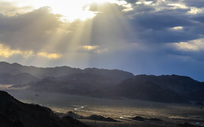 A desert road is highlighted through the clouds in Lake Mead National Recreational Area