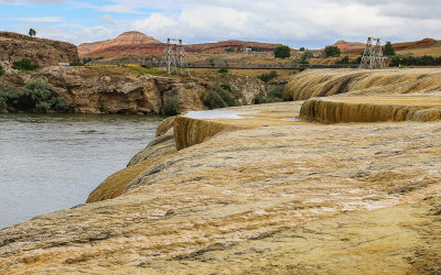 The Rainbow Terraces with the swinging bridge over the Big Horn River in the background in Hot Springs State Park