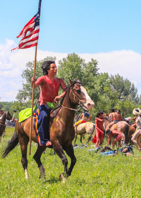 Captured U.S. flag is paraded by an Indian warrior at the Battle of the Little Bighorn
