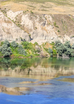 The banks of the Snake River reflected in the water in Hagerman Fossil Beds National Monument