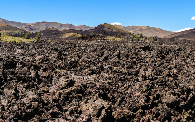 View of the Spatter Cone and Big Craters area over aa lava near the Broken Top Trail in Craters of the Moon National Monument