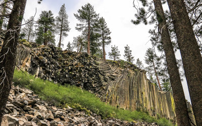 The volcanic basalt postpile through the trees in Devils Postpile National Monument