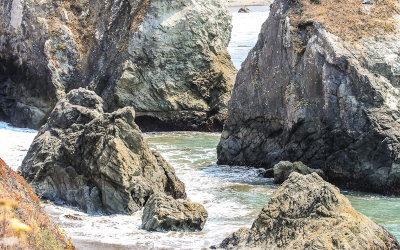 Water surges around boulders on the beach in Point Reyes National Seashore